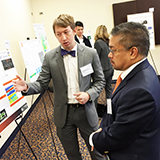 Student explains his research to a judge at Nunan Research Day